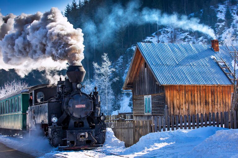 Locomotivă cu abur lângă cabană muntoasă iarna