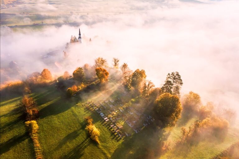 Peisaj de toamnă cu biserică în ceață
