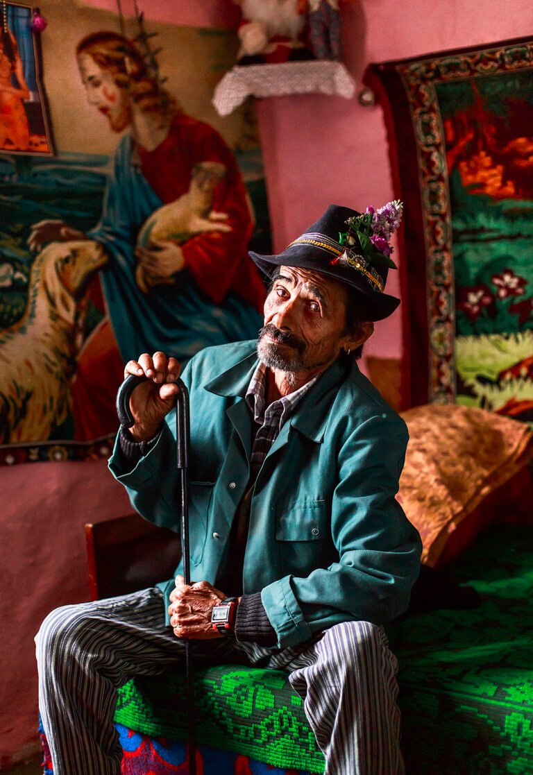 Bărbat în costum tradițional, în interior decorat.