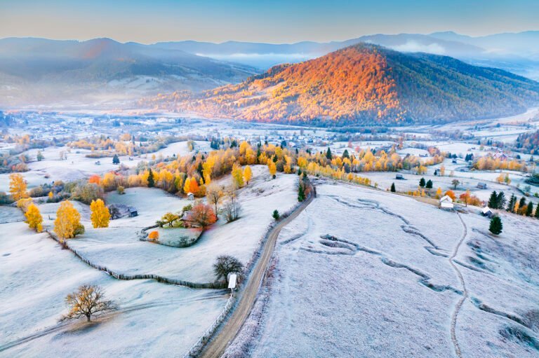 Peisaj montan acoperit de brumă și toamnă colorată.