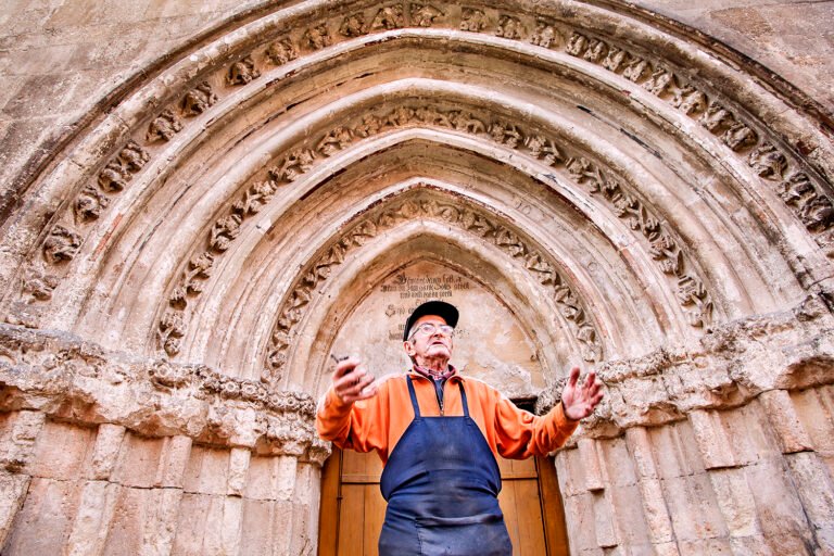 Bărbat în fața unei clădiri istorice, detalii gotice.