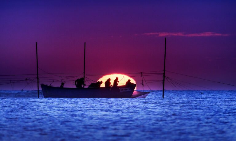 Barcă la apus pe mare.