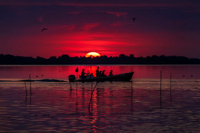 Apus spectaculos peste o barcă pe lac.