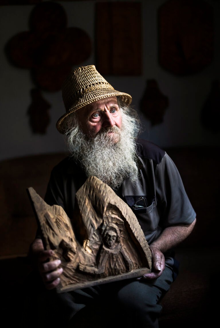 Bărbat bătrân, pălărie, sculptură în lemn, expresie gânditoare.