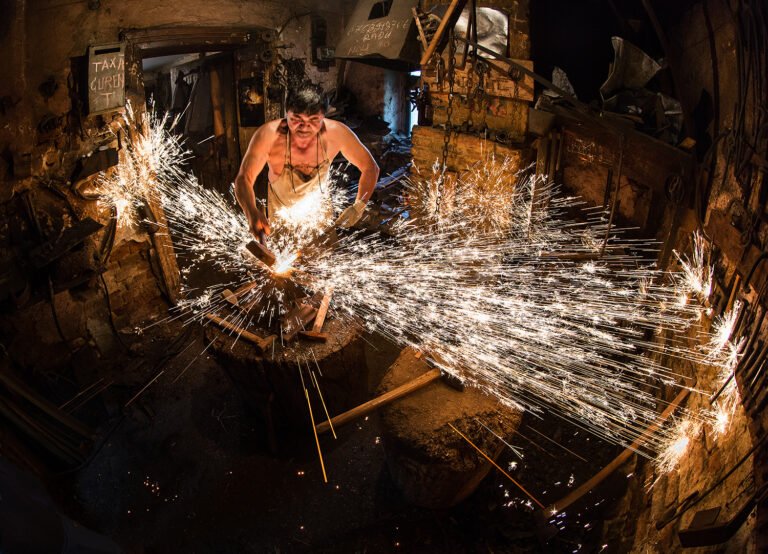 Fierar tradițional lucrând cu scântei în atelier.