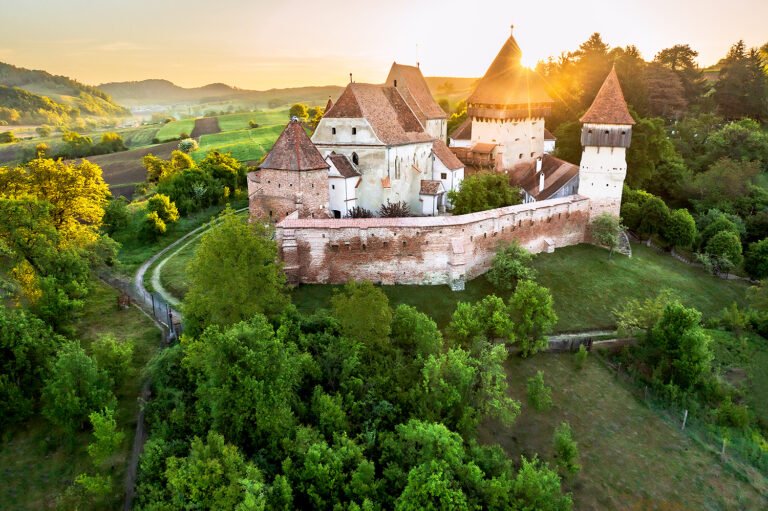 Cetate medievală românească în peisaj natural la apus