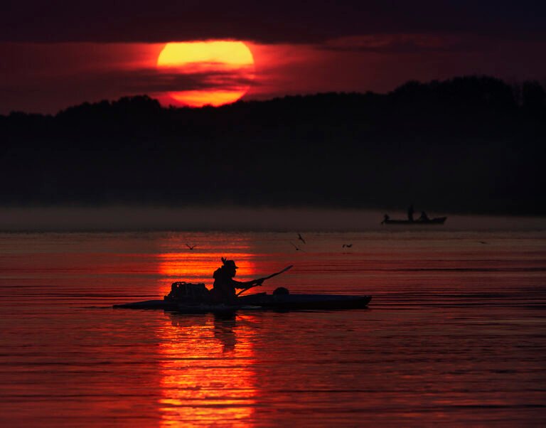Apus de soare peste lac cu canoe